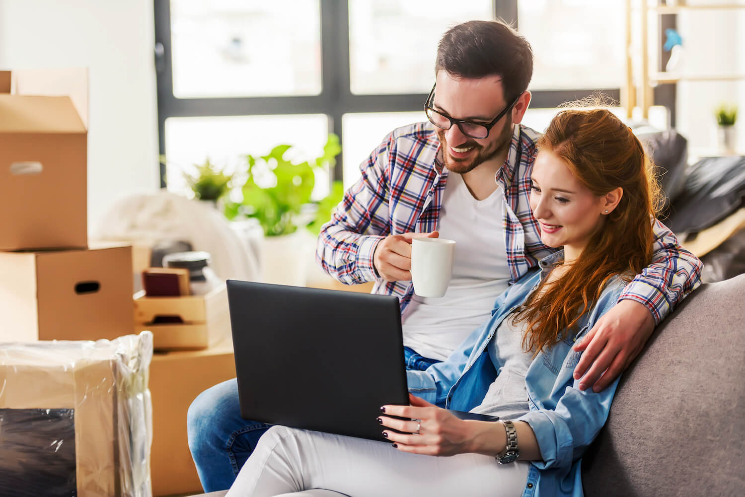 couple smiling looking at laptop