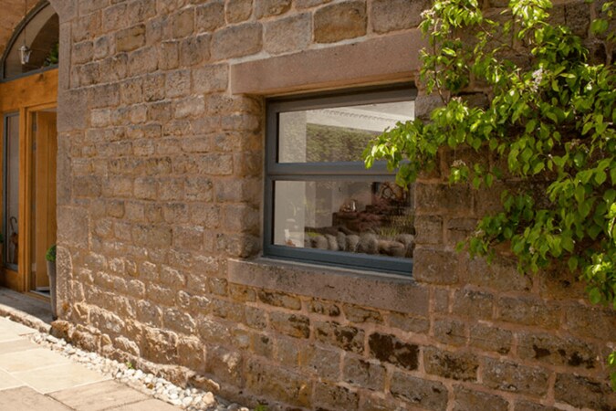 black casement window on a large stone brick house