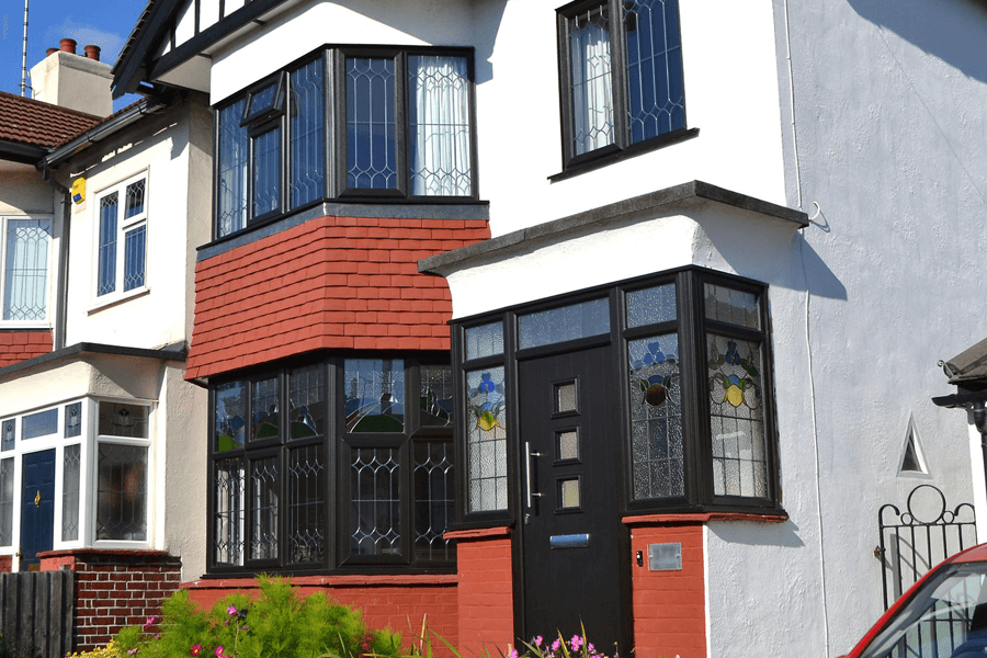 black uPVC bay windows on a white house with black compact door