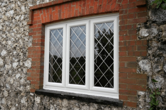 white uPVC casement window with a beaded diamond lead patten