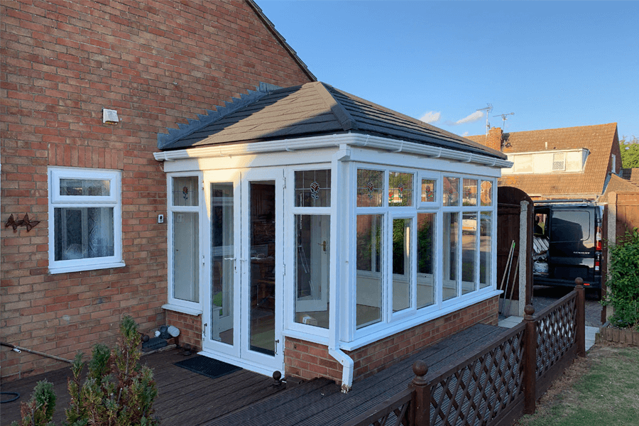 white uPVC conservatory extension with a black tiled roof