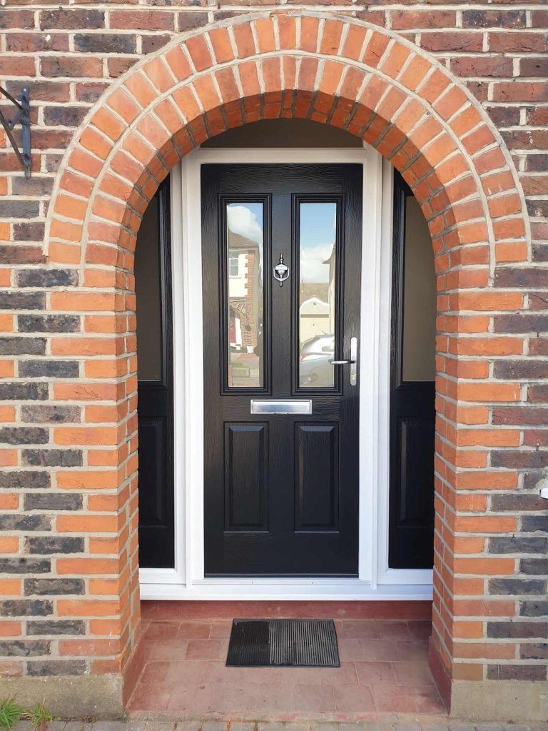 a dark composite front door inside an arch