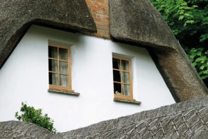 timber effect uPVC flush sash windows on a white thatched cottage