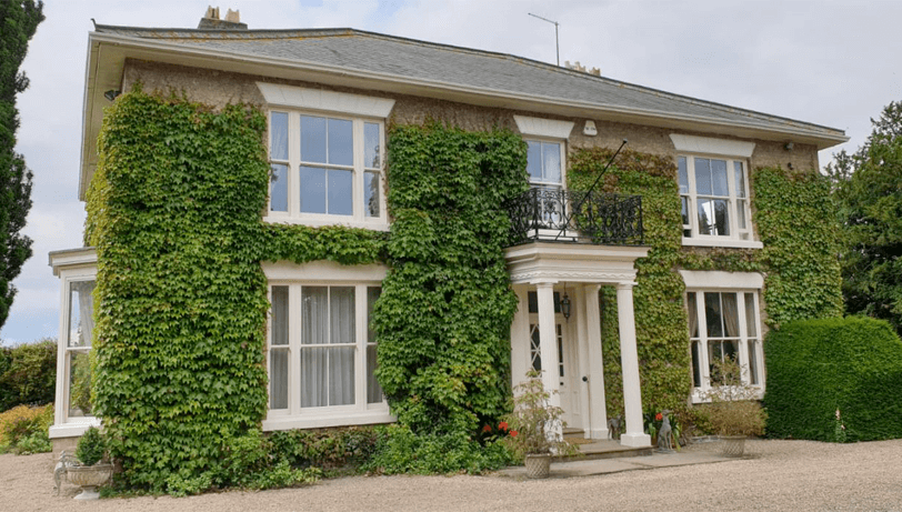 sliding sash windows cream on a ivy covered house