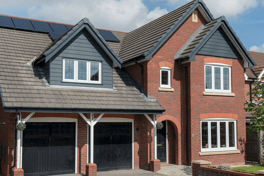 white uPVC windows on a large house with a brown tiled roof