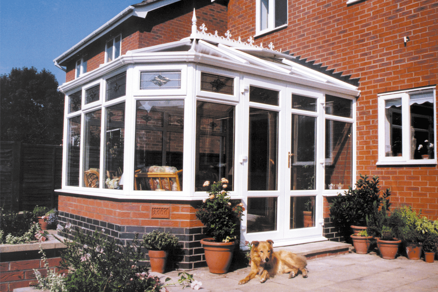 white uPVC victorian conservatory with dog in front